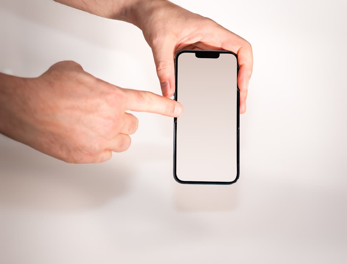 A finger tapping a phone number on a smartphone screen, the moment a lead becomes a call.