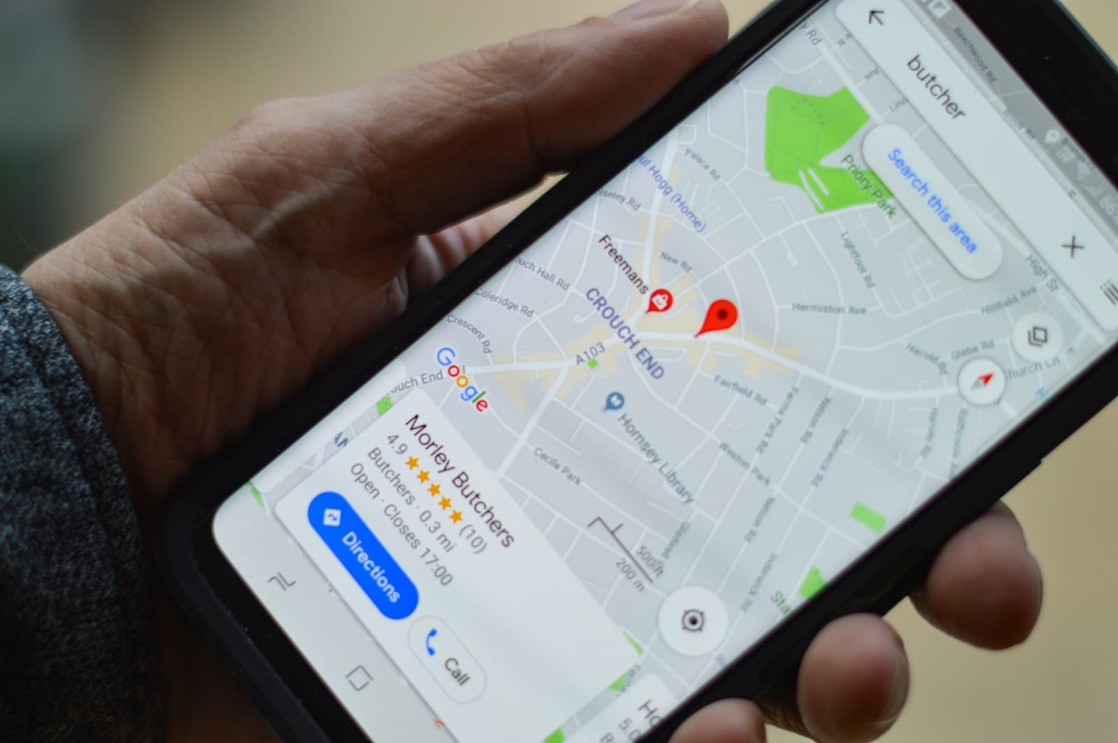 A hand holding a phone with Google Maps open, showing the Map Pack contractors compete for.