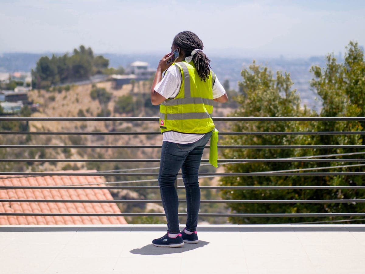 A worker in safety vest on the phone at a job site, the exact kind of in-the-field shot that lifts a Google profile.