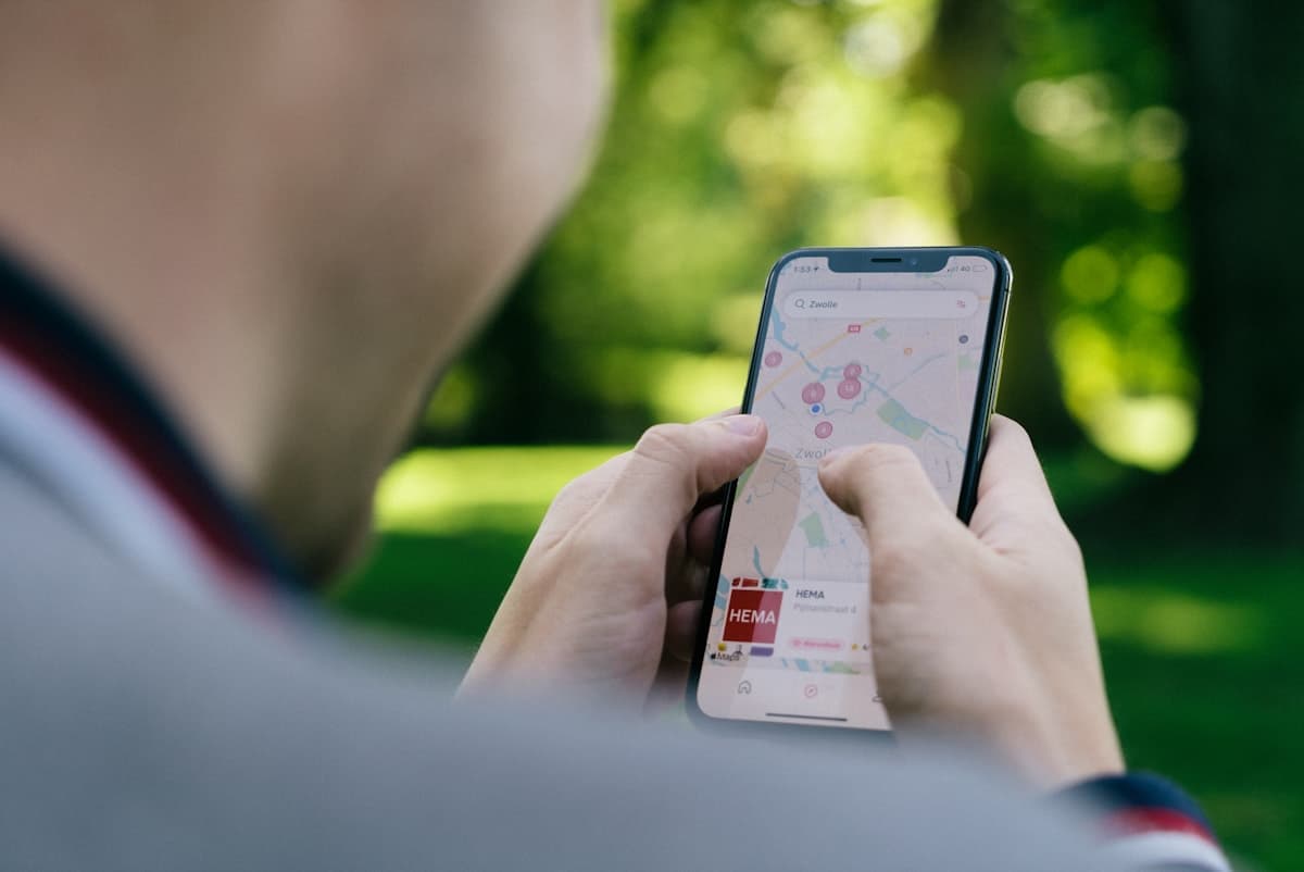 A homeowner using a phone in the city, the actual moment of a local search that decides which contractor wins the call.